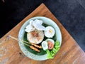 Indonesian Fried Rice with Satay, Egg, and Crackers on a Rustic Wooden Table Royalty Free Stock Photo