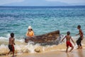 Indonesian funny children with a white lady playing with a huge log in the water