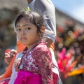 Indonesian girl holding onto her mother`s hand.