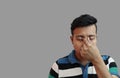 Indonesian guy weeping in depressed mood with fingers on both eyes in grey background with copy space for .Sad mood Royalty Free Stock Photo