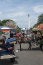 Indonesian horse carriages` drivers wait at Merdeka Square with the National Monument in the background in Jakarta, Indonesia.