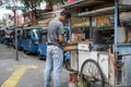 Indonesian man checks his money at his food pushcart in a street in Jakarta