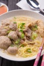 Indonesian Meatball Bakso Noodle with sweet soy sauce and chilli sauce sprinkle with green onion