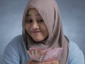 Indonesian Muslim Woman Holding Rupiah Money Royalty Free Stock Photo