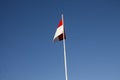 Indonesian national flag (red and white) flying against a blue sky background. Royalty Free Stock Photo