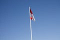 Indonesian national flag (red and white) flying against a blue sky background. Royalty Free Stock Photo