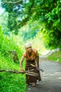 Indonesian old woman looking for dried wood for cooking