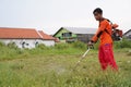 Indonesian people cutting the grass