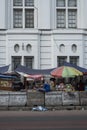 Indonesian people walk by street food stalls in a street near Kota in Jakarta , Indonesia