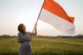 Indonesian pregnant woman holding bamboo stick with big flag Royalty Free Stock Photo