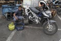 Indonesian scooter mechanic works outside