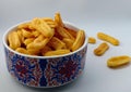 Indonesian snack. Close-up of cheese soes crackers or crisps in bowl against white background
