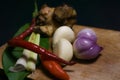 Indonesian special spices that are on a wooden cutting board are ready to be cooked and consist of shallots, garlic, chilies