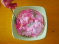 Indonesian street food, refreshing coconut milk mixed with ice fruit and syrup, called es buah or es kacang. Close up, hand