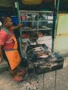 Indonesian street vendor selling grilled fish