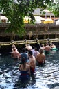 Indonesian and tourism pray and bath themselves in the sacred waters of the fountains, in Tirta Empul, Bali