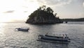 Indonesian traditional boats with outriggers Bangka at harbor in sunset.