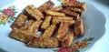 Indonesian traditional meal named Tempe Goreng. fried fermented soybean cake served in a white plate  top down view angle shootin Royalty Free Stock Photo