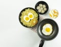 Indonesian Warm noodles served with eggs and fresh tomatoes with meatballs on a black bowl and pickled on a white bowl and eggs on