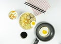 Indonesian Warm noodles served with fresh tomatoes and meatballs on a white round bowl and pickles on a white bowl on a white