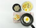 Indonesian Warm noodles served with fresh tomatoes and meatballs on a white round bowl and pickles on a white bowl on a white