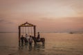 Muslim bride and groom riding in the sea at sunset