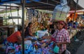 Indonesian woman with a bag on her head buys vegetables on the local street market