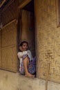 Indonesian woman sitting at her front door