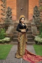 Indonesian woman wearing Balinese kebaya standing against a temple Royalty Free Stock Photo