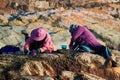 Indonesian women sort the fishing catch by sitting on a rock by the sea in the evening. Concept of aboriginal life.