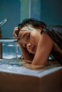 Indonesian Women wash her hand in the sink while their hair was wet Royalty Free Stock Photo