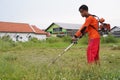 Indonesian Worker mow the lawn