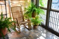 indoor balcony with bamboo rocking chair and potted ferns Royalty Free Stock Photo