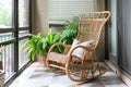 indoor balcony with bamboo rocking chair and potted ferns Royalty Free Stock Photo