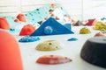 Indoor climbing wall hall. Multicolored climbing holds and volumes marked with climbing magnesium chulk