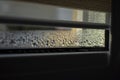 Indoor close-up of a leaky window with steam and condensate background