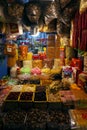 Indoor dried food market with many stalls in yellow lamp