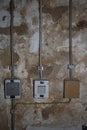 Indoor electric equipment control industrial button power switch wire cables closeup old aged weathered grungy brick retro wall