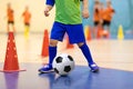 Indoor football futsal training for children. Soccer training dribbling cone drill. Indoor soccer young player with a soccer ball Royalty Free Stock Photo