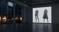 Indoor gallery space featuring a large digital projection displaying two mannequin Royalty Free Stock Photo