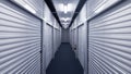 Indoor hallway with metal storage unit doors on each side.