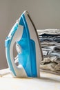 Indoor housework - steam iron and pile of folded clothes