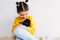Indoor image of a happy child smiling and playing at home with little dog. Pretty little girl cares about the puppy. Adorable kid Royalty Free Stock Photo