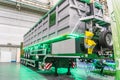 Indoor industrial setting with a large, green machine enginegenerator and a person working at a computer station Artificial Royalty Free Stock Photo