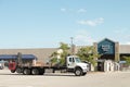 indoor lumber yard sign on storefront with parking lot and large truck in front. p