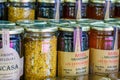 Indoor market display: glass jars filled with various preserved foods, including honey
