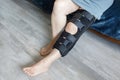 Indoor photo of woman with bandage orthosis compression knee brace support injury