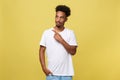 Indoor photo of young African American man pictured isolated on grey background pointing to his white blank T-shirt Royalty Free Stock Photo
