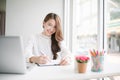 Indoor picture of smiling Asia woman working with notebook laptop