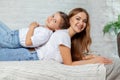 Indoor portrait of a beautiful mother with her charming little daughter posing against bedroom interior. Royalty Free Stock Photo